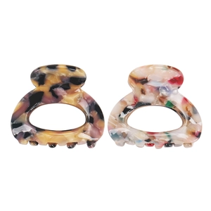 Dettaglio di piccole mollette per capelli in acetato con design a tartaruga e marmo