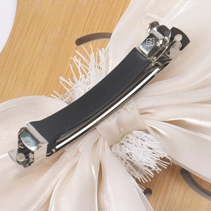 Détail de la pince à ressort et du tissu en organza sur la grande barrette à nœud