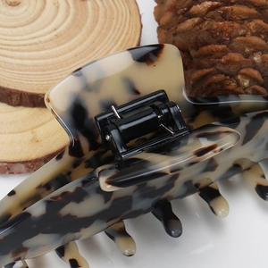 Detail view showing metal spring and tortoise shell texture of large hair claw clip