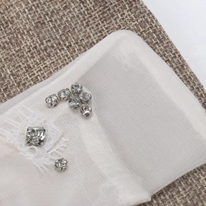 Vue détaillée du ruban en organza blanc avec strass en cristal et broderie en dentelle