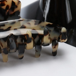 Macro view of large leopard print hair claw clip showing polished tortoiseshell texture