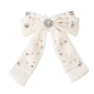 Détail d'un nœud en organza avec centre en cristal scintillant et strass dispersés
