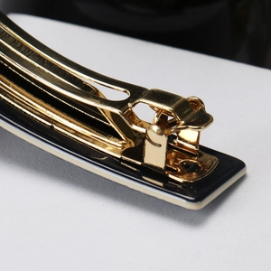 Detail of the high-quality golden metal spring mechanism on a retro acetate hair clip