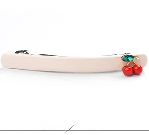 Vue détaillée de la barrette en acétate rose pâle avec cerises rouges et gemme verte
