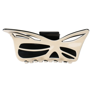 Detail of a large cream and black acetic acid hair claw clip with cutout bow design
