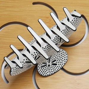 Detail of large cream hair claw clip with black polka dots and polished acetate finish