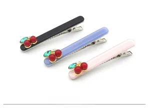 Détail de barrettes cerise en acétate noir, bleu et rose avec des pinces en métal argenté