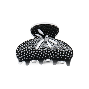 Detail view of the black and white polka dot acetate hair claw with floral cutout