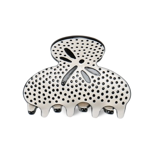 Elegant large acetate hair claw clip with black polka dots and leaf pattern on white base