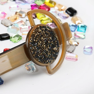 Detail of French vintage hair clip featuring amber resin and inlaid dark rhinestones