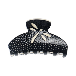 Detail view of the spring mechanism on a black dragonfly pattern hair claw clip