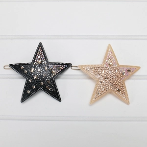 Vue détaillée des pinces à cheveux étoiles en acétate avec strass brillants noirs et champagne