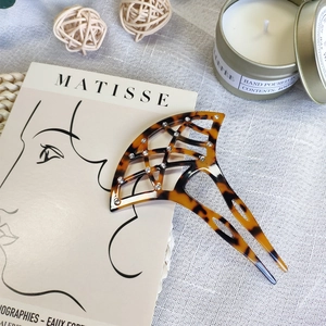 Detail of fan-shaped acetate hair fork with tortoiseshell pattern and inlaid rhinestones