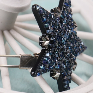 Détail macro d'une pince à cheveux en étoile avec cristaux bleu foncé brillants
