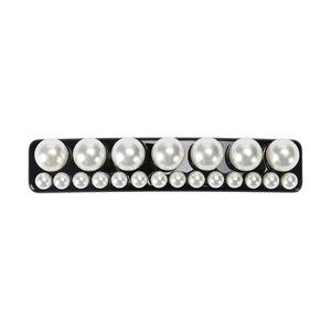 Détail d'une barrette à cheveux avec double rangée de perles sur base noire