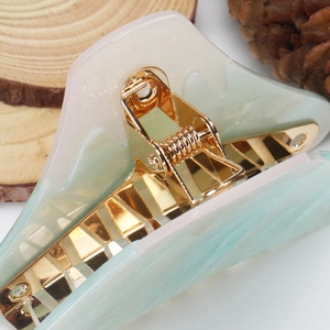 Detailed macro view of the marble texture acrylic hair claw clip with golden spring