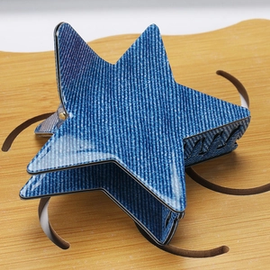 Détail de la pince à cheveux étoile avec motif denim bleu et dents noires de fixation