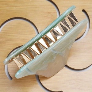 Detail view of large marble acrylic hair claw clip with golden metal spring and smooth teeth