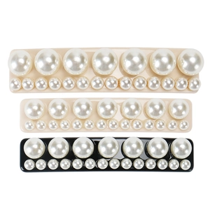 Vue détaillée de barrettes rectangulaires ornées de perles en beige et noir