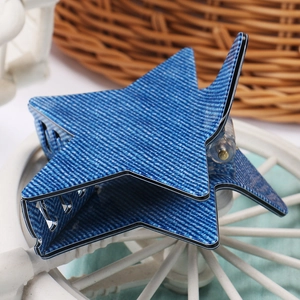 Détail de la pince à cheveux en forme d'étoile avec texture denim bleu et dents solides