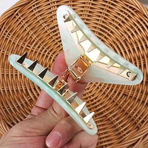 Detailed view of large marble texture acrylic hair claw clip with gold metal spring