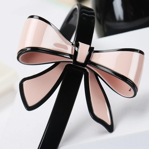 Dettaglio del cerchietto con fiocco rosa e nero in acetato lucido di alta qualità