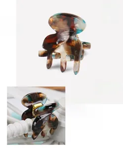 Close-up of acetate mini hair claw with tortoise shell pattern and metal spring detail