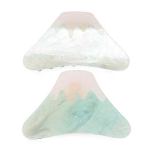 Close-up of marble pattern acrylic hair claws with pink and green gradient and gold glitter