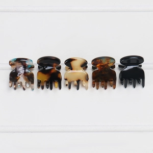 Close-up of five acetate mini hair claws in tortoiseshell and black patterns