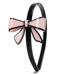 Dettaglio del cerchietto in acetato lucido con decorazione a fiocco rosa e nero