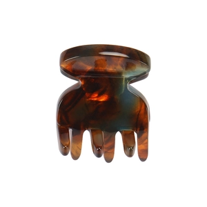 Close-up of a mini acetate hair claw clip featuring tortoise shell texture and polished finish