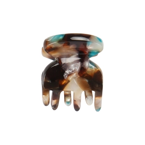 Detailed macro view of a mini amber marble acetate hair claw with high-gloss finish