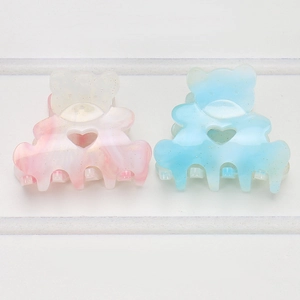 Close-up of mini bear hair claws with marble texture and heart-shaped hollow detail