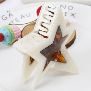Detailed top view of a cream-colored star hair claw clip with shell texture pattern
