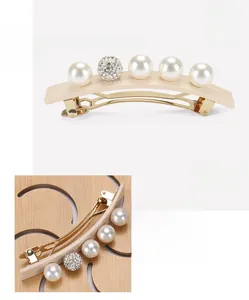 Macro view of acetate spring hair clip featuring white pearls and rhinestone spheres