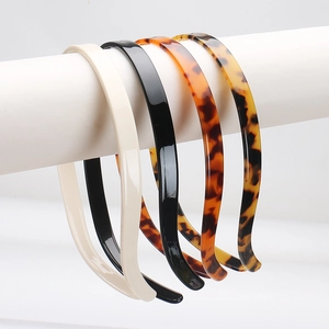 Detail view of four slim leopard and tortoise shell acetate headbands in minimalist style