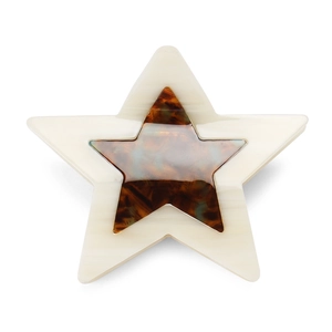 Detail of star-shaped acetate hair claw clip featuring creamy marble and tortoiseshell patterns