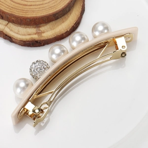 Detail view of acetate hair clip with large faux pearls and sparkling crystal ball