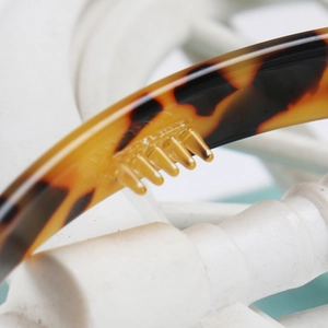 Detail view of leopard acetate headband showing anti-slip teeth and tortoise pattern