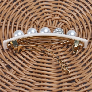 Close-up of pearl and rhinestone acetate hair clip with Made in France gold metal detail
