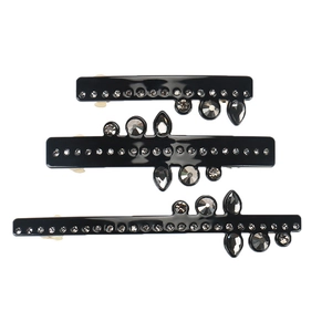 Trois barrettes à cheveux noires élégantes avec cristaux gris sur fond blanc brillant