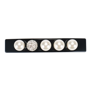 Detail of a rectangular hair clip with white pearls and a sparkling rhinestone bead