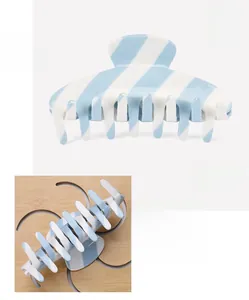 Detail of blue and white striped acetate hair claw clip showing size and multi-tooth grip