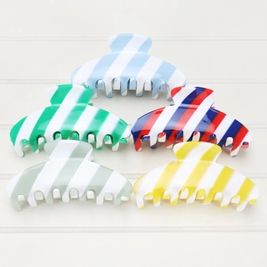 Detail view of large acetate claw clips with classic diagonal stripe patterns in five colors