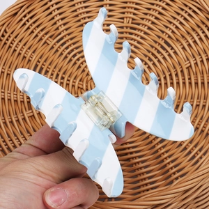 Detail showing the strong metal spring and blue white striped acetate butterfly hair claw