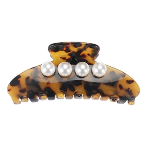 Detail view of tortoiseshell acetate hair claw clip with four elegant white pearls