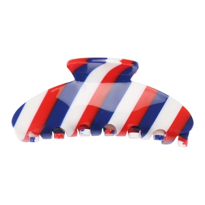Detail of large acetate hair claw clip featuring classic red, white, and blue diagonal stripes