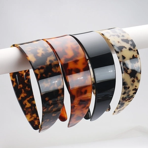 Close-up of four wide leopard print and tortoiseshell cellulose acetate headbands with teeth