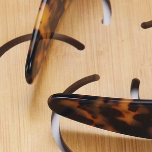 Detail of premium tortoiseshell acetate hairband showing polished texture and smooth rounded ends