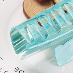 Macro detail of the semi-transparent blue marble acetate hair claw clip with cross-teeth